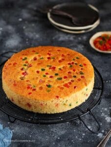 Eggless rava cake on a round black wire rack