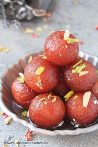 Close-up short of gulab jamuns in a shallow silver pewter bowl