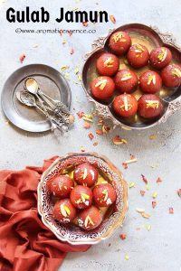 Gulab jamuns served in a silver tray and bowl.