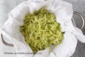 shredded cucumber in a colander lined with cheesecloth for tzatziki