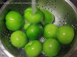 Rinsing tomatillos under running water.