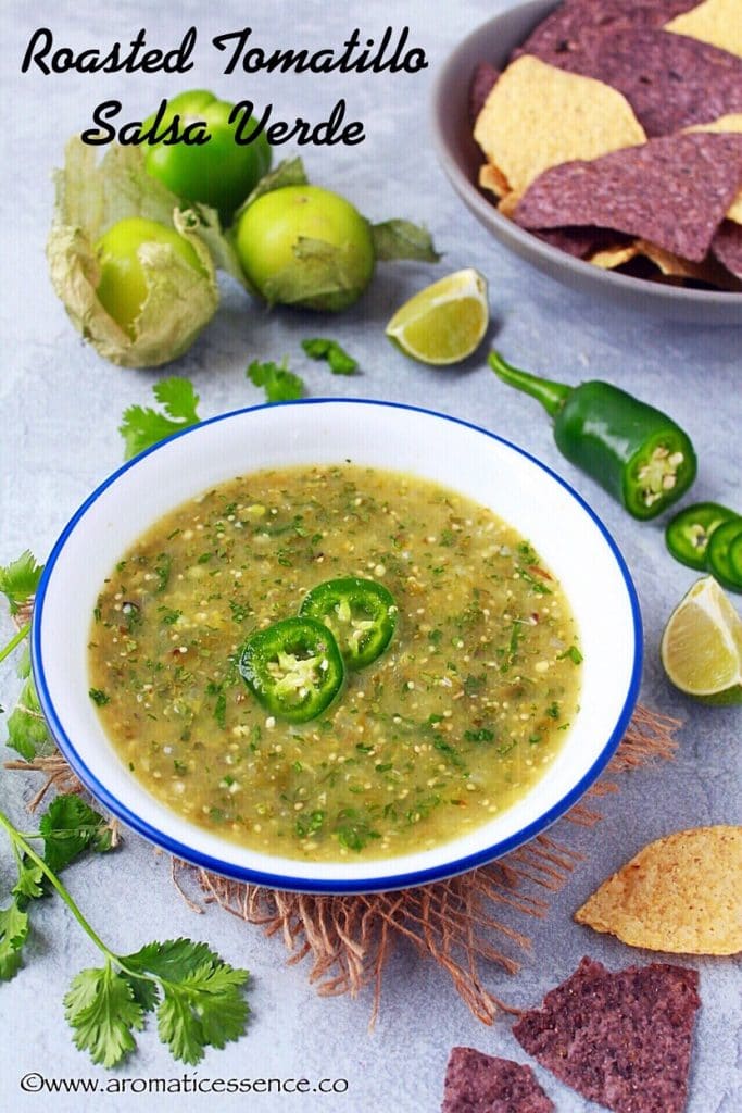 Salsa verde in a white bowl, garnished with serrano pepper slices.