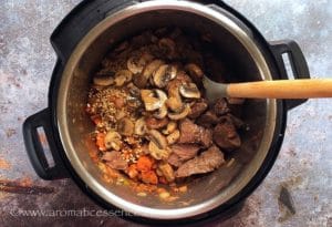 Add the rinsed barley, browned meat along with its juices and sauteed mushrooms to the pot. 