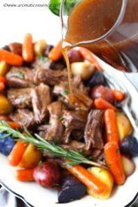 Pouring gravy over shredded beef pot roast