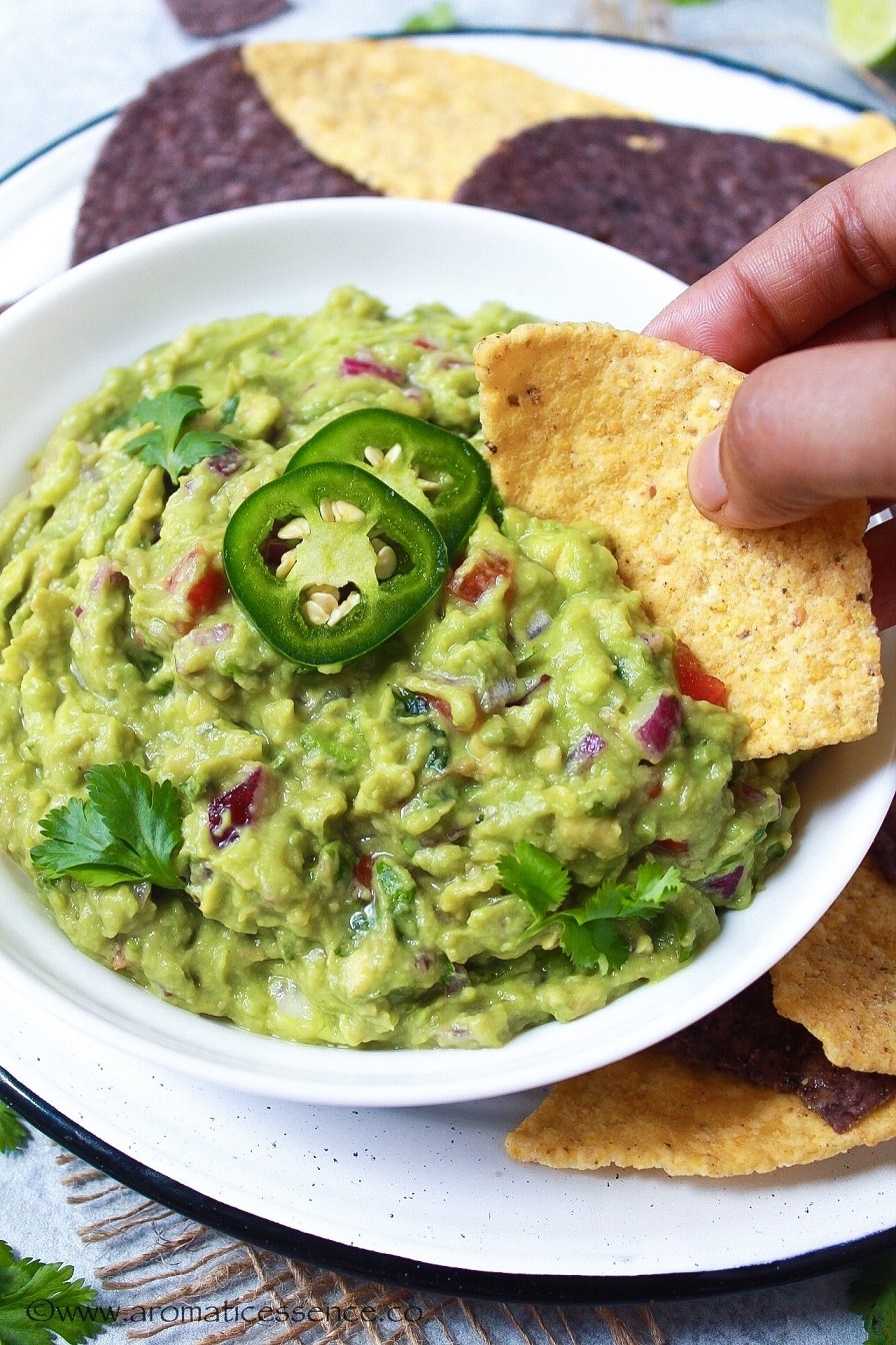 Scooping up some guac with a tortilla chip.