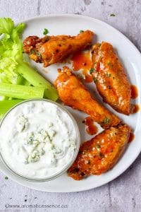 Buffalo wings and celery sticks served with blue cheese sauce