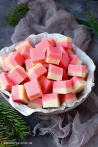 Coconut ice squares placed in a grey shallow bowl