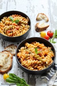 Feta pasta served in two black bowls along with crusty bread