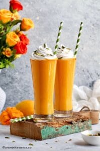 Mango milkshake served in two tall glasses