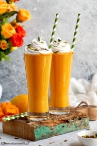 Mango shake topped with whipped cream and slivered pistachios