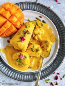 Partially melting mango kulfi on a marble plate
