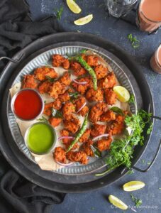 Overhead shot of murgh pakora in a rimmed galvanized plate