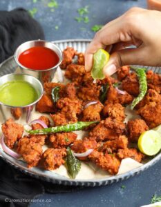 Drizzling lemon juice over the pakoras