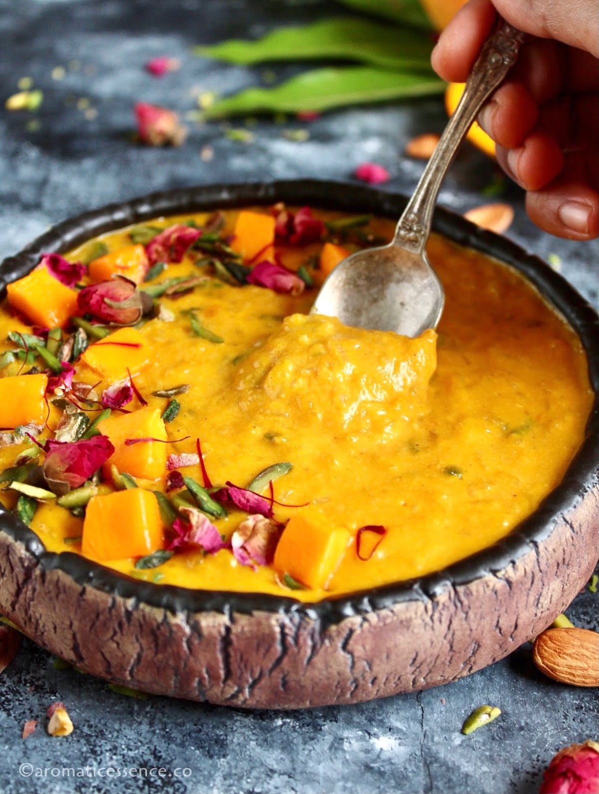 Digging into a bowl of traditional mango kheer with a spoon