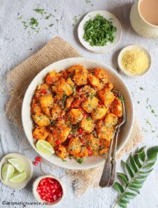 Overhead shot of bread upma served with extra garnishes like pomegranate, coriander leaves, nylon sev, and lemon juice