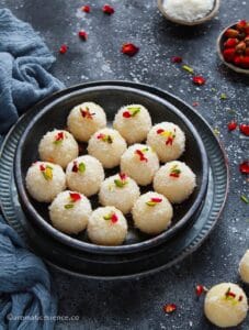 Coconut ladoo served in a black shallow bowl