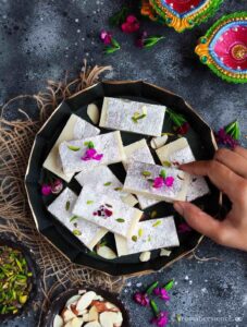 Holding a piece of burfi