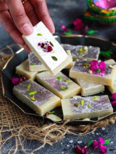 Holding a piece of plain burfi