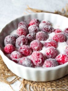 Cranberries coated in simple syrup and tossed in sugar in a shallow fluted ramekin