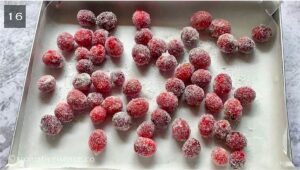 Sugar-coated cranberries in a baking tray lined with parchment paper