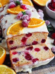 Cranberry orange bread topped with orange glaze and garnishes