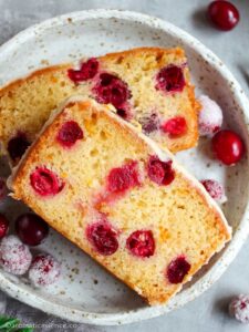 Overhead shot of orange cranberry loaf in a ceramic speckled plate