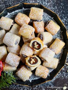 Overhead shot of date rolls cookies dusted with icing sugar