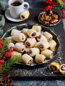 45 degree angle shot of date roll biscuits in a black metal tray