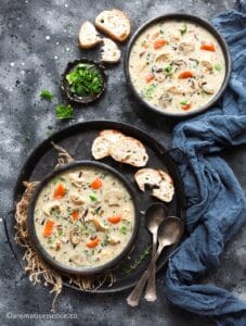 Overhead shot of Instant Pot wild rice soup with chicken served in two black bowls