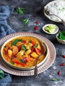 Instant Pot Thai Yellow chicken curry served in a white shallow bowl along with a bowl of rice