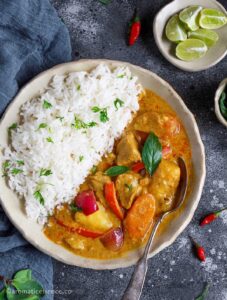 Thai yellow curry served with basmati rice in a shallow irregular shaped bowl