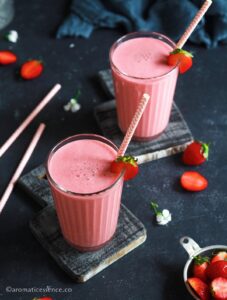 Strawberry lassi served in 2 ribbed glasses