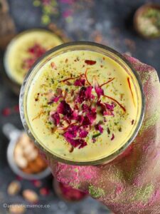 Close-up shot of sardai garnished with dried petals, pistachios, and saffron