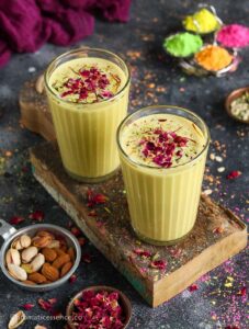 45 degree angle shot of thandai served in 2 glasses, placed on a rustic serving board