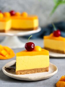 Close-up shot of eggless, no-bake mango cheesecake slice served on an off-white plate
