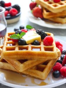 Close up shot of a stack of egg-free waffles on a white plate