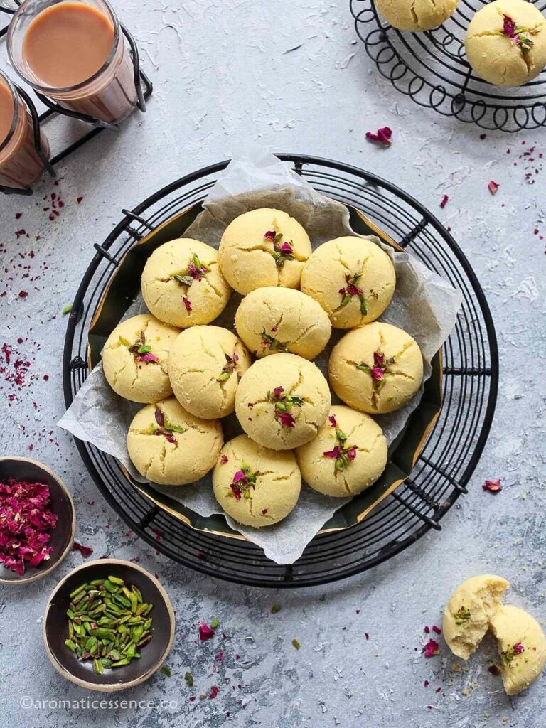 Eggless nankhatai cookies served in a round metal tray lined with parchment paper