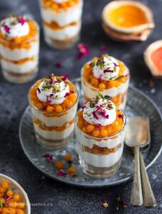 Three boondi cheesecake shots served on a round metal tray