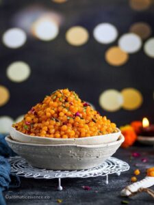 Sweet boondi served in white ceramic bowls places on a round white rack