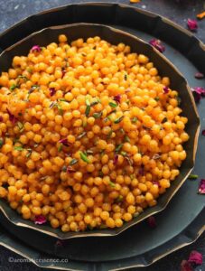 Close-up shot of sweet boondi garnished with slivered pistachios and dried rose petals