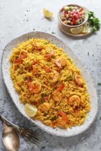 45 degree angle shot of jhinga biryani served on a white speckled platter